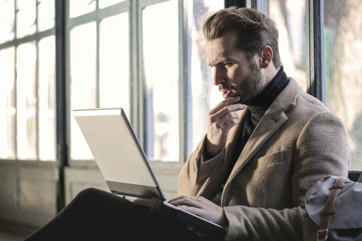 A man thinking while looking at his laptop