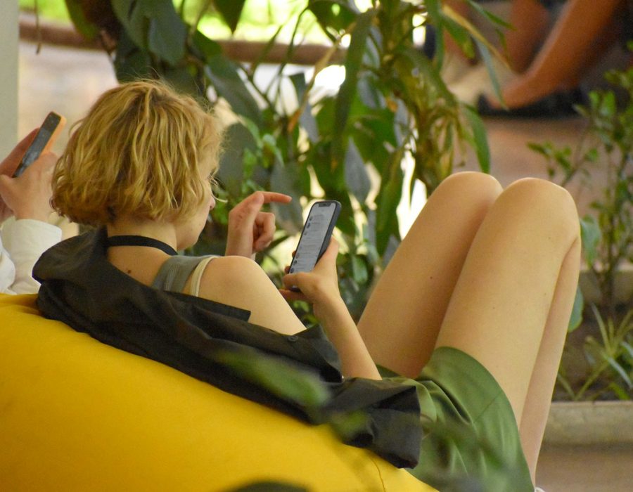 A woman relaxing in a beanbag, scrolling on her phone