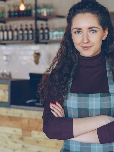 A cafe owner standing behind her counter
