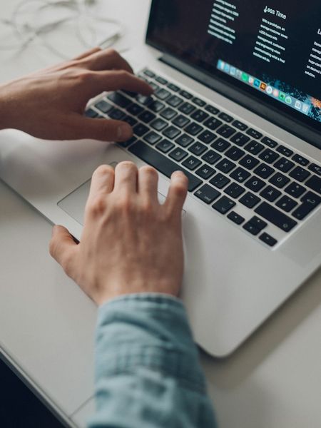 Hands typing on a laptop